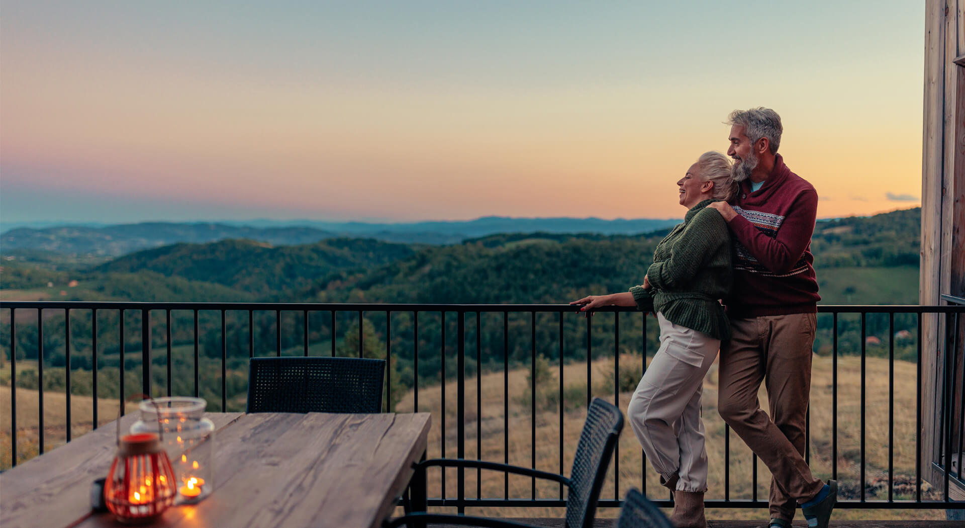 image showing a senior couple cuddling on a balcony
